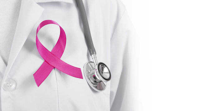Doctor woman with pink ribbon on her chest, supporting symbol of breast cancer awareness and international women day campaign.