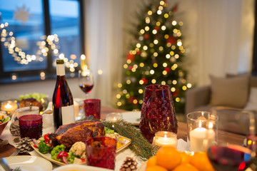 christmas dinner and eating concept - food and drinks on table at home