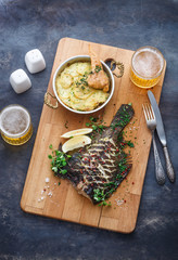 Delicious baked flounder with potato gratin and beer, top view.