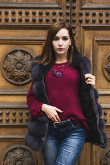 Fototapeta na wymiar The woman beautifully poses in a fashionable claret pullover
