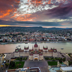 Fototapeta premium Budapest, Hungary - Aerial panoramic view of the Parliament of Hungary at sunset with sightseeing boats on River Danube and beautiful dramatic purple clouds