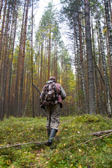 Fototapeta premium hunter with a gun in a pine forest