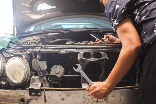 Handyman services  holding a screwdriver and Search for information from mobile phones.