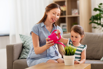 pregnancy, people and family concept - happy pregnant mother teaches her little daughter to take...
