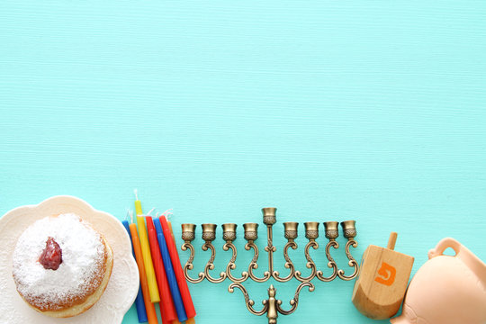 Top view image of jewish holiday Hanukkah background with traditional spinnig top, menorah (traditional candelabra) and candles.