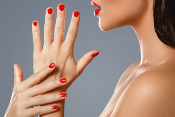 Beauty and cosmetics. Female mouth and nails with red manicure and lipstick.