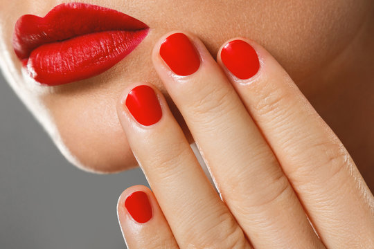 Beauty and cosmetics. Female mouth and nails with red manicure and lipstick.