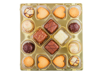 Luxury belgian chocolate and biscuit cookies selection in original golden tray and white background.