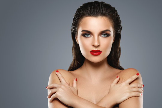 Portrait of beautiful young woman with a red lipstick and nail polish
