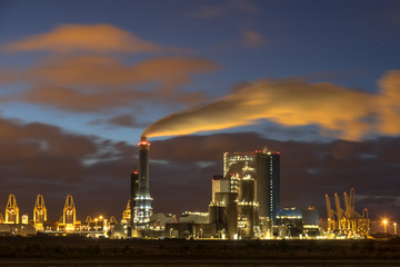 Industrial landscape with illuminated clouds at night