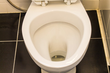 White toilet Black tile floor, orange light