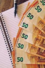 Economía y finanzas. Billetes de 50 euros, cuaderno y bolígrafo.