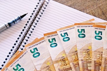 Economía y finanzas. Billetes de 50 euros, cuaderno y bolígrafo.