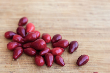 Bright red dogwood (cornel) on the wooden background. Close up, indoors, copy space.