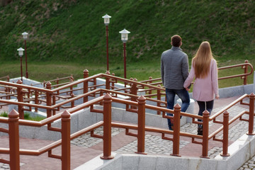 Spring walk of young people walking down the stairs holding hands.