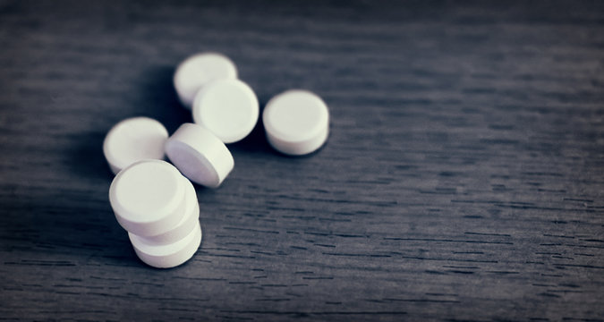 Multiple Round White Tablets Randomly left on a Table.