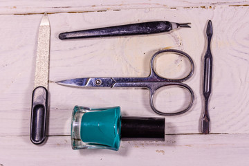 Different manicure tools and nail polishes on wooden table. Top view