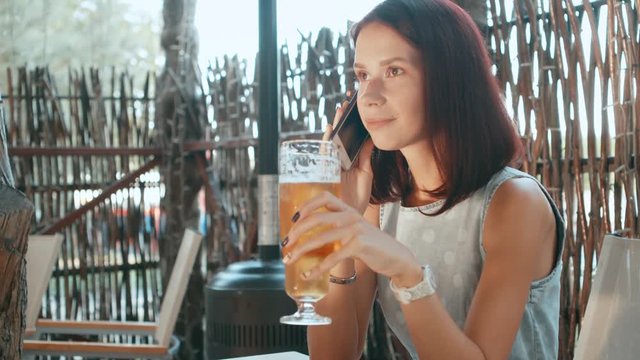 Young girl drinking beer in a street bar.
