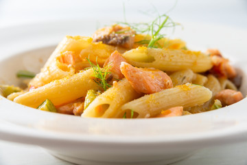 Piatto di penne con salmone, zucchine e bottarga 