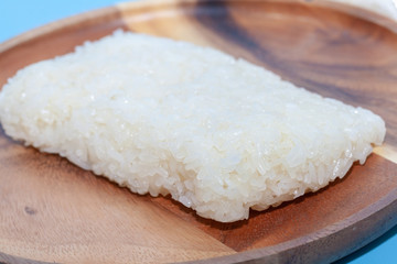 Obraz na płótnie Canvas close up of sticky rice in wooden plate on blue background