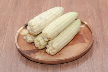 close up of waxy corn in wooden plate