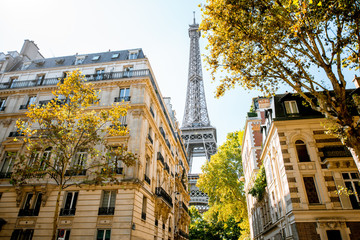 Beautiful street view with old residential buildings and Eiffel tower during the daylight in Paris - obrazy, fototapety, plakaty