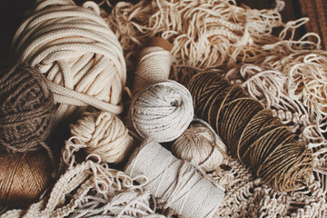 Needlework, macrame, knitting. Yarn and thread of natural colors in a wicker basket. Women's hobby.