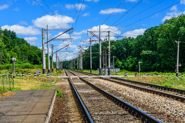 Fototapeta na wymiar View on a railroad track and white clouds in blue sky