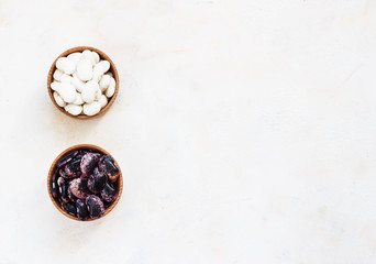 Navy beans in wooden bowl, also haricot, pearl haricot, boston, white or pea bean. Dried seeds of Phaseolus vulgaris, a legume. food photo close up from above on white background