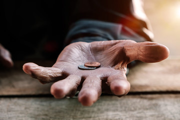 hand old man begging for money because of the hunger on the wood table. vintage tone