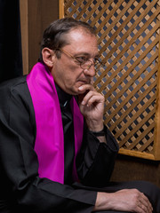 Portrait of a priest in his confessional