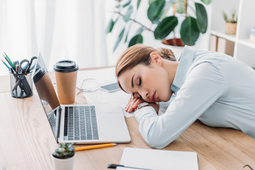 overworked adult businesswoman sleeping at workplace in modern office