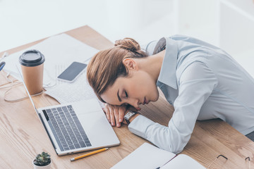 high angle view of exhausted adult businesswoman sleeping at workplace