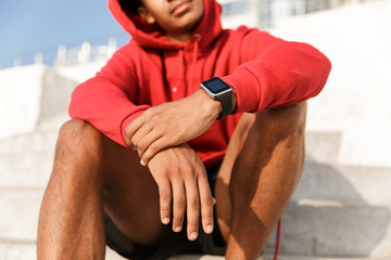 Obraz premium Cropped image of african man in hoodie sitting outdoors