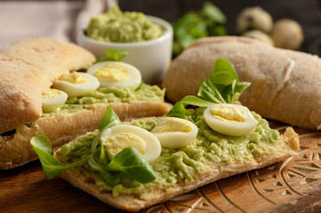 Avocado sandwich ciabatta with quail eggs.
