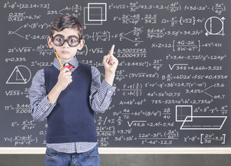Education concept with funny geek school boy in front of a blackboard