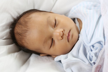 Fototapeta na wymiar Asian Infant in to sleeping on the bed.