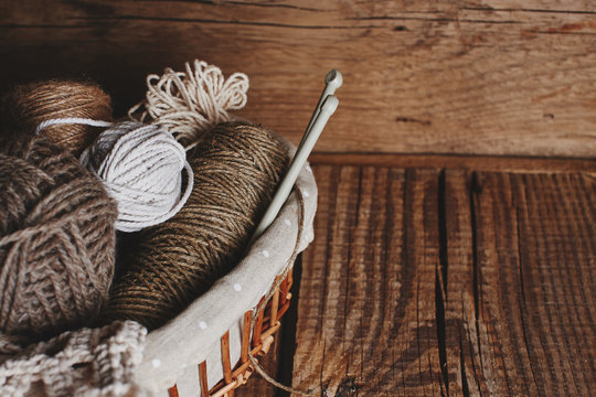 Needlework, macrame, knitting. Yarn and thread of natural colors in a wicker basket. Women's hobby.