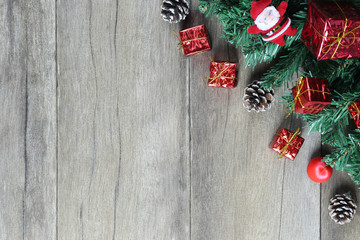 Green Pine and Christmas Decoration Equipment on wooden floor.