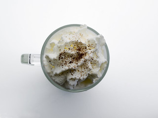 Taza de cristal con nata montada en su interior vista cenital