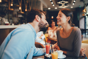 Young happy couple at a date in a coffee shop