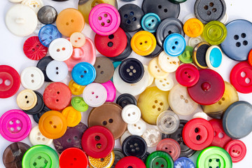 Colored buttons from old clothes for craft in bulk on a white background