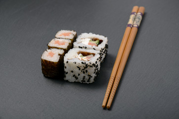 sushi on the black table with chopsticks