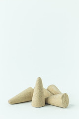 Incense Cone in a stand with the feather for background.