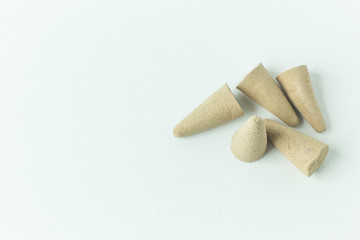Incense Cone in a stand with the feather for background.