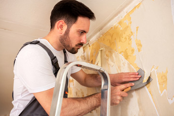 Handyman is using a putty knife