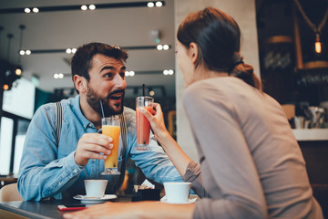 Young happy couple at a date in a coffee shop