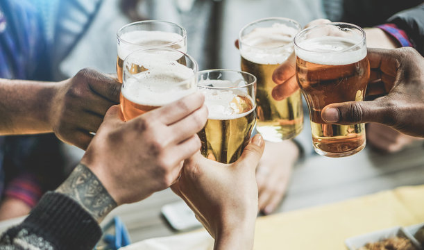 Group of friends cheering with beers in pub restaurant