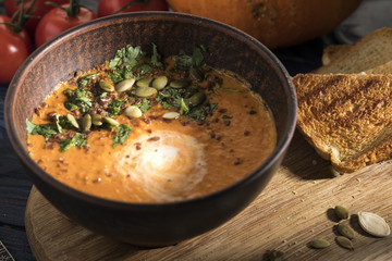 Pumpkin cream  soup with toasts and pumpkin seeds. Toned photo. Closeup