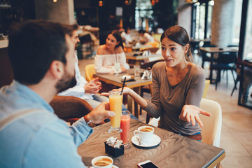 Young happy couple at a date in a coffee shop